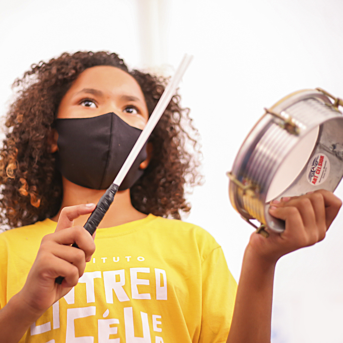 Foto de criança na oficina de percussão